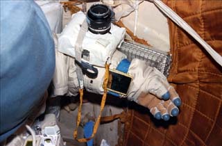 Views of the Mir space station airlock including Orlan suits. Camera and mirror are attached to the glove of the space suit.